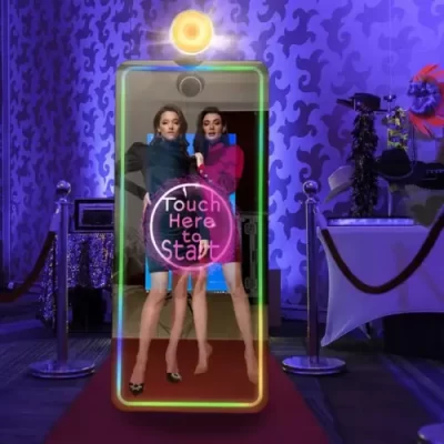 two women posing in front of mirror photo booth