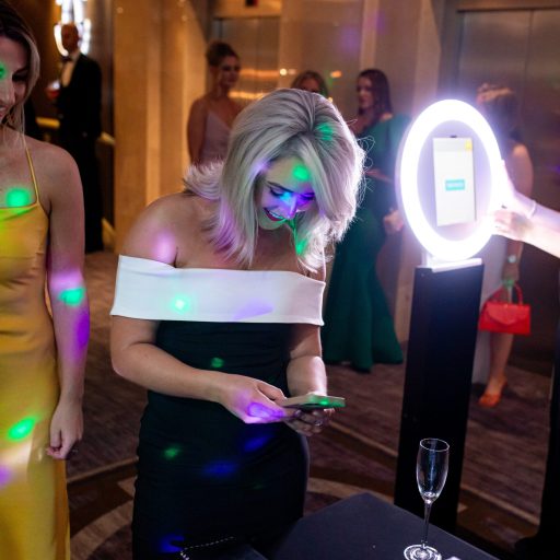 A lady at a party enjoying having her face drawn by the Sketch Bot