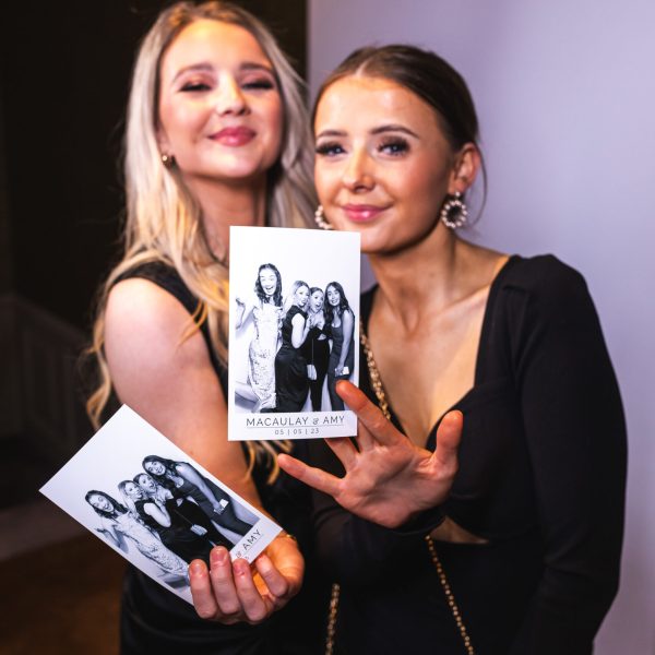 Lovely ladies at a wedding or party showing a copy of their photo taken and printed out