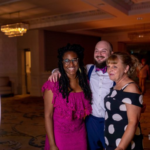 Two pretty ladies and a gentleman at an event, posing together for photos in front of the Mobi Aura